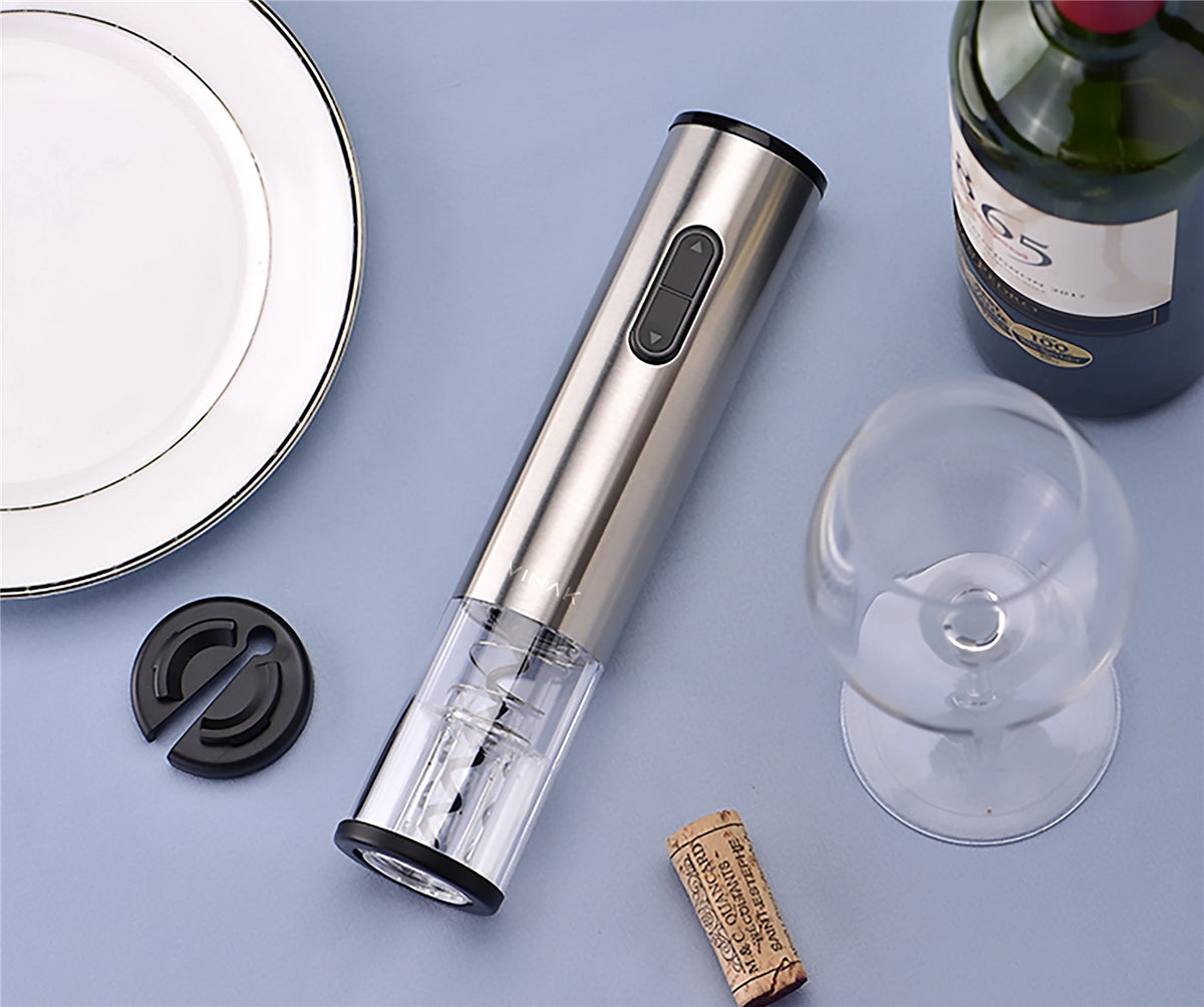Sacacorchos eléctrico de acero inoxidable junto a una copa de vino