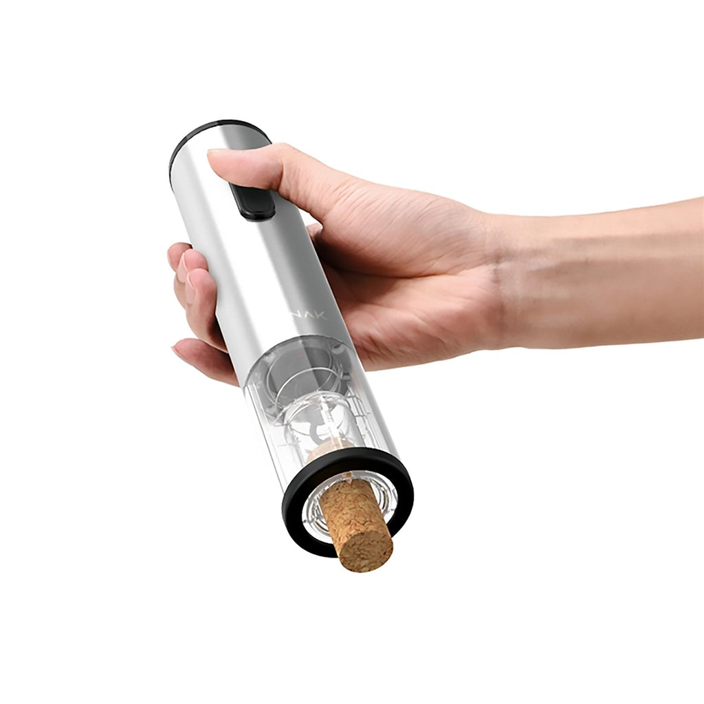 Sacacorchos eléctrico de acero inoxidable junto a una copa de vino